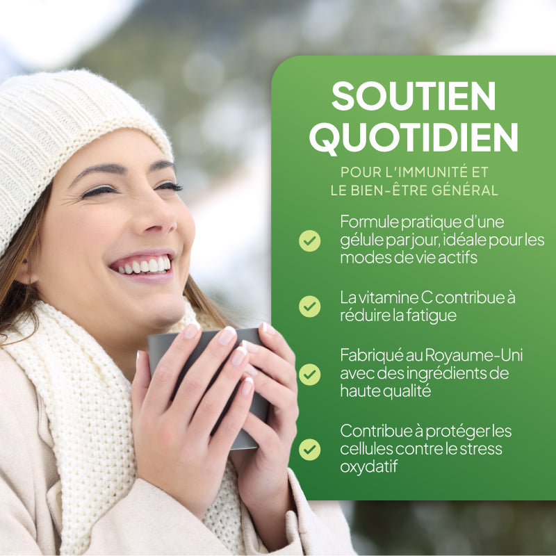 Une femme souriante, coiffée d'un bonnet en tricot blanc et vêtue d'un pull crème, tient une tasse à la main, à côté d'un grand panneau vert sur lequel figure un texte en français encourageant à prendre soin quotidiennement de son système immunitaire et de son bien-être général.